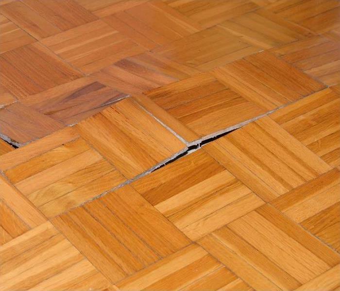 Buckling hardwood floor caused by water damage in Atlanta home
